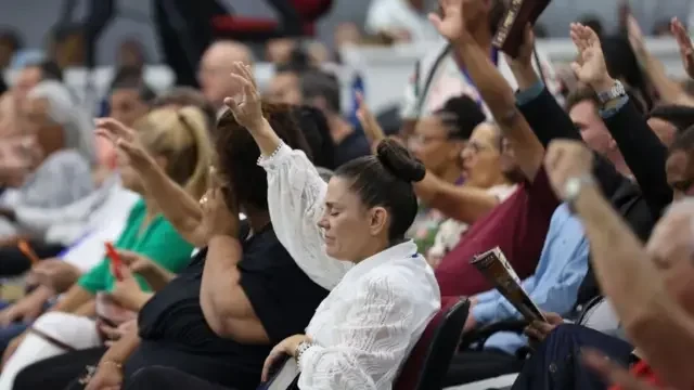 Fiéis com os braços erguidos durante culto evangélico em Balneário Camboriú, Santa Catarina, em 23 de abril de 2024